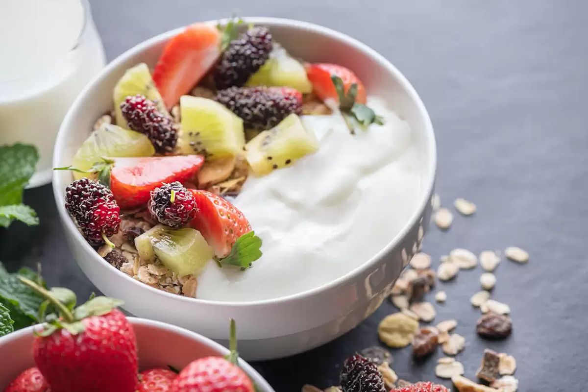 Bowl of nutritious foods including fruits, nuts, and yogurt for thyroid health