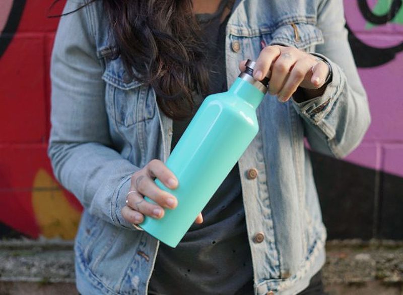 Woman opening reusable water bottle