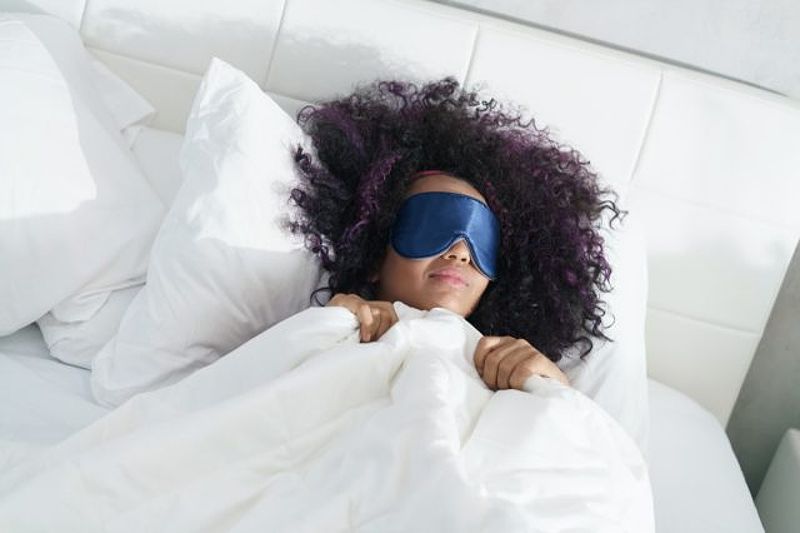 Woman sleeping in bed with eye mask